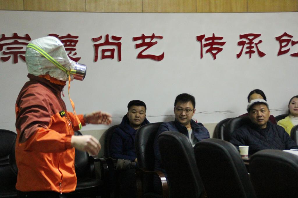 图为消防安全知识宣传员在演示消防器材的使用方法