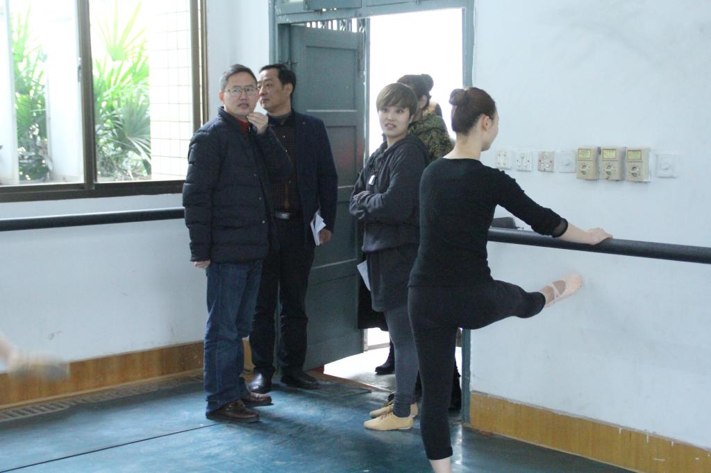 图为龙先琼副董事长向任课老师了解教学情况